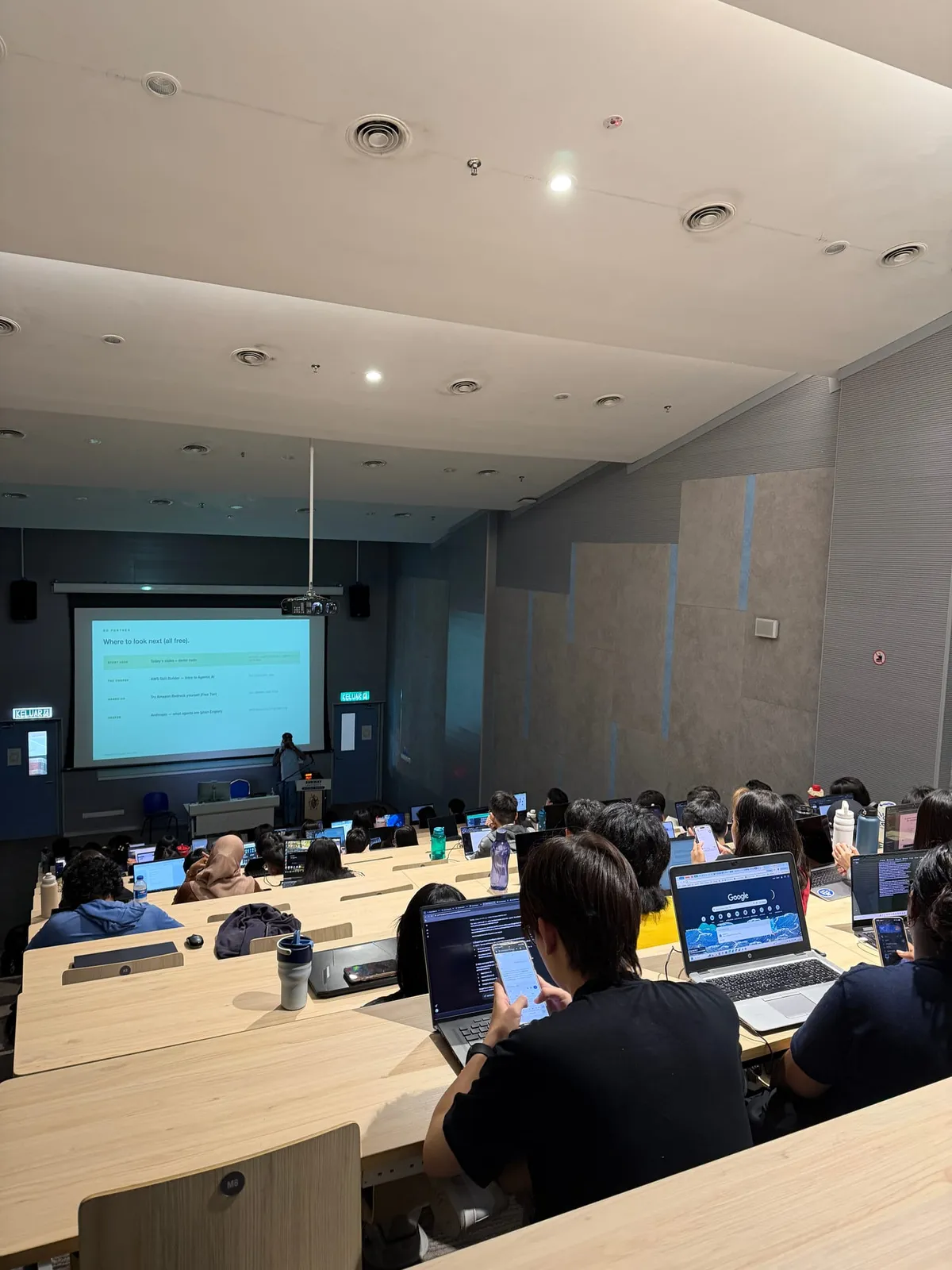 View from the back of a packed Sunway University lecture theatre, students with laptops open